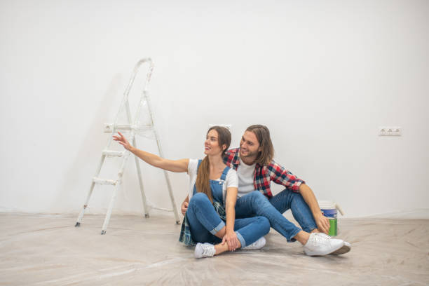istock Happy couple sitting on the floor and making selfie 1288148791