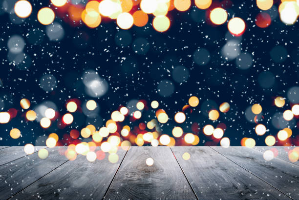 istock Abstract Snowy Christmas Background. Wooden Table With Defocused Lights 1288149853
