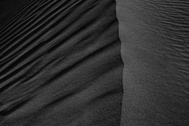 istock Black Sand dune. Black Sand beach macro photography. Background, texture, wave pattern of oceanic sand on the beach, black. Texture of beach sand. Black beach. 1288151020