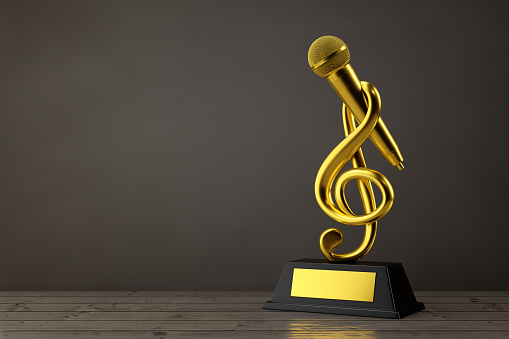 Golden Music Treble Clef with Microphone Award Trophy on a wooden table. 3d Rendering