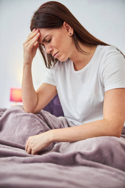 istock Suffering female placing a hand on her forehead 1288151389