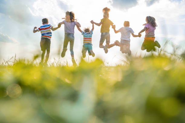 istock Group of kids jumping in nature 1288153452