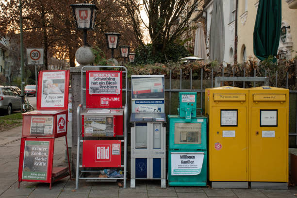 Mailboxes and Newspaper Vending Machines Next to a Beer Garden in Munich, Germany Munich, Germany - November 24, 2020: Mailboxes and newspaper vending machines selling the most important national and local publications stand next to the beer garden of a restaurant. süddeutsche zeitung photos stock pictures, royalty-free photos & images