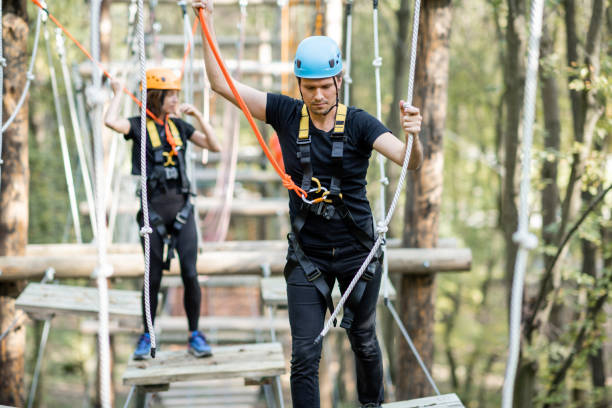 istock Man and woman climbing ropes in a park 1288162241