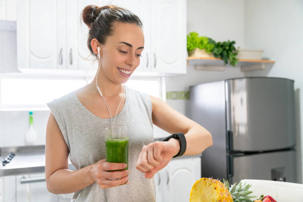 istock Woman drinking a green smoothie at home before her workout 1288162581