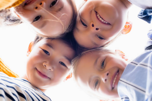 istock Bottom view of multiethnic kids smiling at camera isolated on white 1288162715