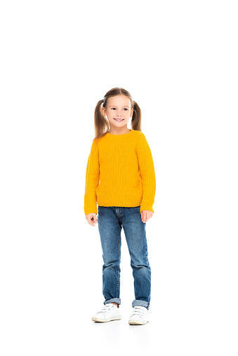 Smiling girl looking away while standing on white background