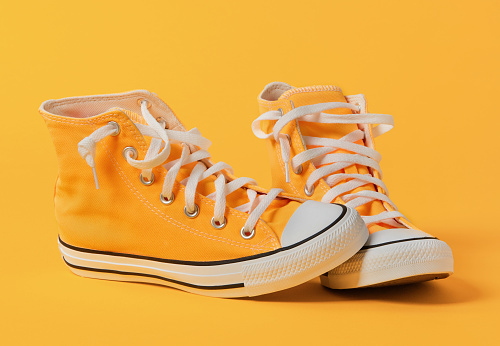 Yellow canvas shoes on yellow background