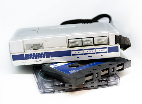 Old portable stereo audio tape cassette player isolated on a white background. Obsolete technology. 80s. Listening to music.