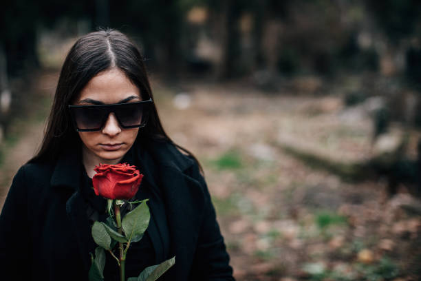 istock Sad widow carries flowers to a grave 1288171954