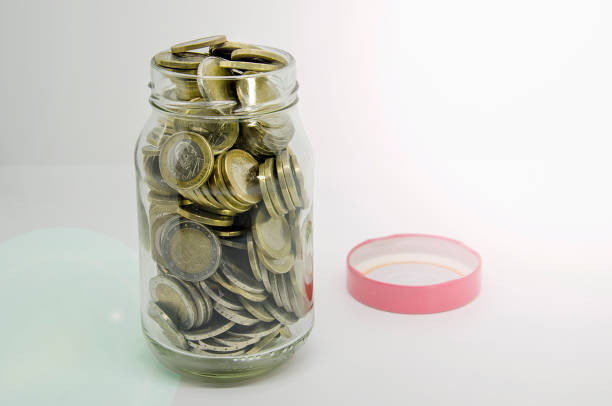 Euro coins are being collected in a glass jar, symbolizing saving and financial planning