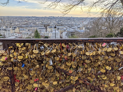 Love locks at the feet of the Basilica of the Sacred Heart, Montmartre with a view on Paris city.