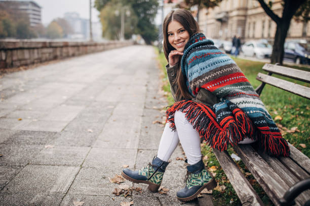 istock Modern woman sitting on a bench in city 1288181616