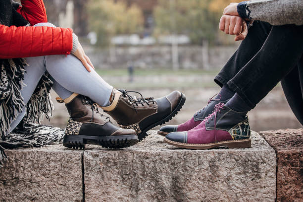 istock Couple in modern boots sitting outdoors in city 1288182504