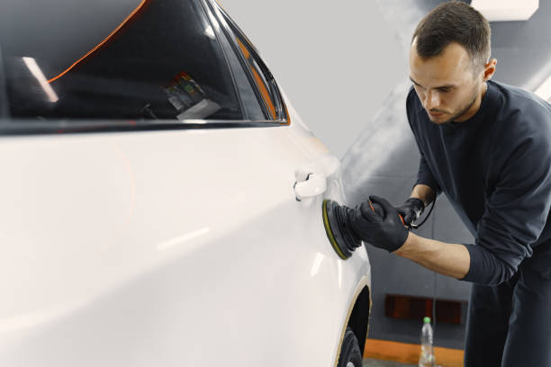 istock Man polish a car in a garage 1288190238
