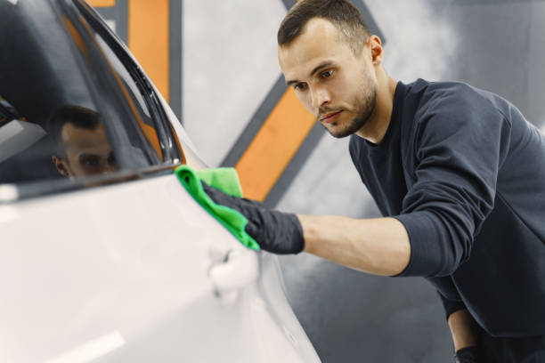 istock Man polish a car in a garage 1288190243