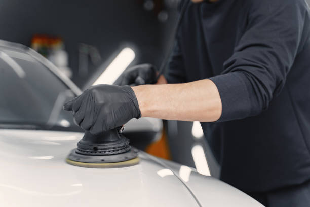 istock Man polish a car in a garage 1288190280