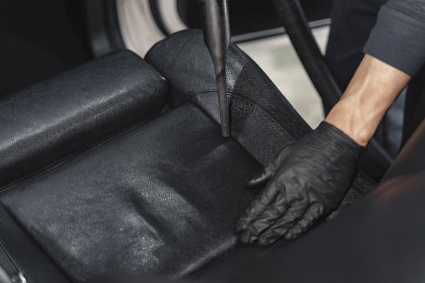istock Man hoovering a car cabin in a garage 1288190310