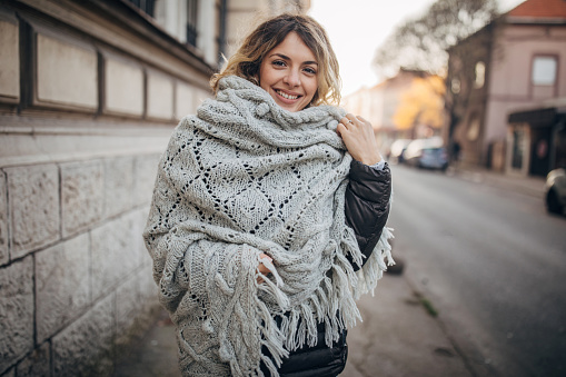 One woman, beautiful young fashionable woman standing on the city street.