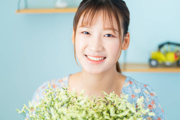 A beautiful young Asian girl holding a bouquet of flowers just received by her boyfriend on International Women's Day