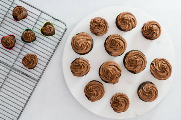 istock Many chocolate cupcakes decorated with chocolate frosting closeup on kitchen table directly from above 1288202307