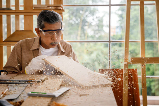istock Senior carpenter blowing sawdust. 1288203732