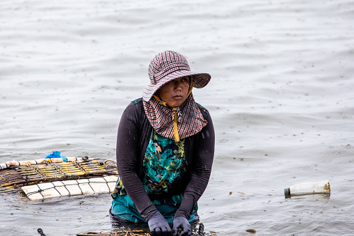 A Cambodian woman looking after crab nets at the Kep Crab Market on the Gulf Of Thailand. Kep, Cambodia, is 20 km from the town of Kampot, Cambodia