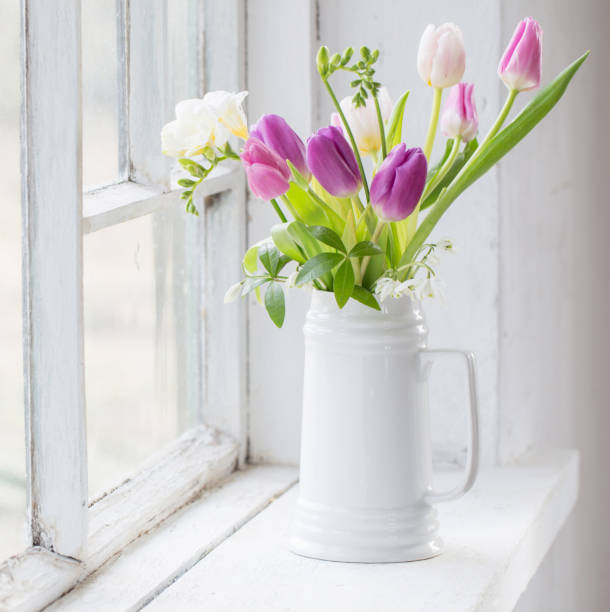 istock beautiful tulips on old white windowsill 1288204525