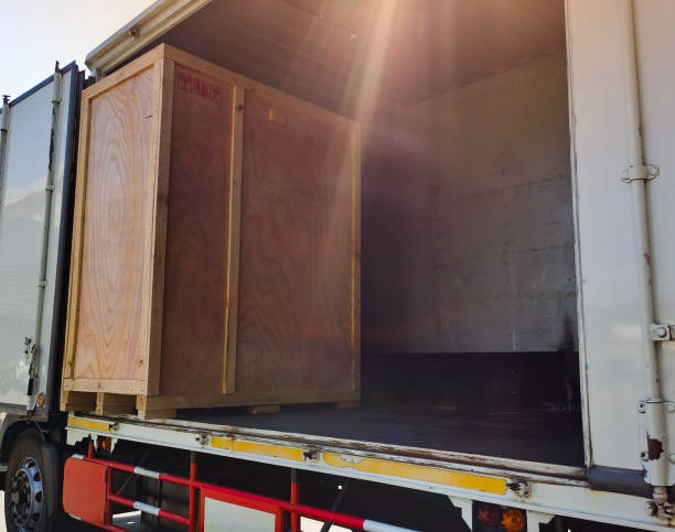 istock Worker driving forklift loading shipment carton boxes goods on wooden pallet at loading dock from container truck to warehouse cargo storage in freight logistics, transportation industrial, delivery 1288207521