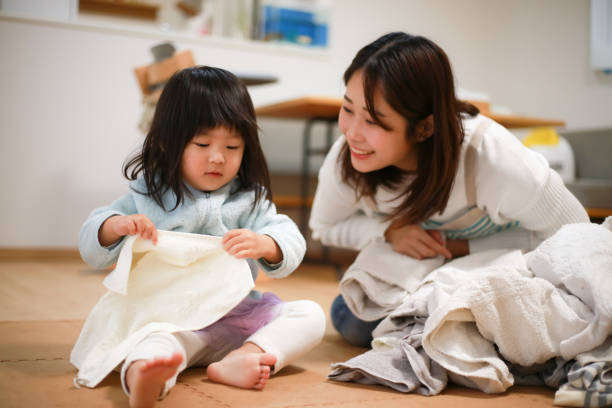istock A girl helping to fold the laundry 1288211058