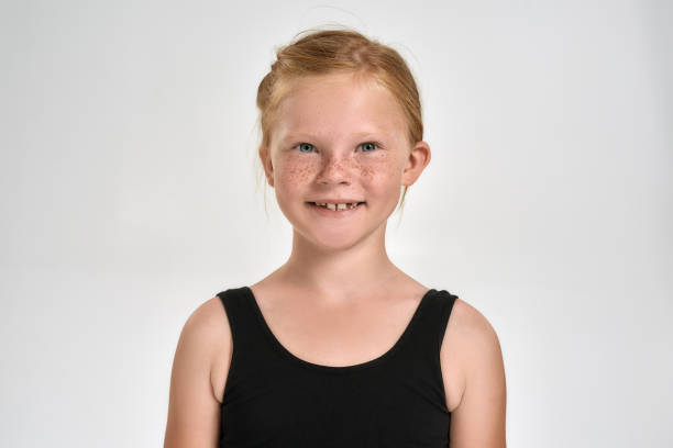 portrait of pretty little red haired sportive girl in sportswear smiling at camera while standing isolated over white background - gymnastics smiling little girls only isolated on white imagens e fotografias de stock