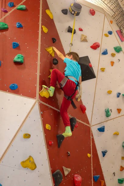 istock Young boy climbing with rope on climbing wall 1288218689