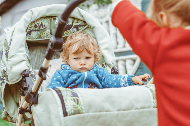 istock sister plays with her brother in a stroller 1288222515
