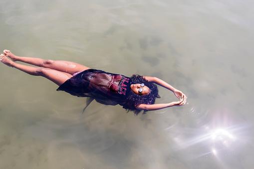Beautiful young African American woman floating in a pool of water