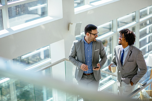 Two business colleagues talking while ascending stairs