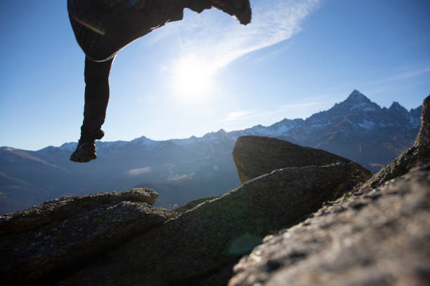 istock Hiker leaps across sunny mountain ridge in the morning 1288230045