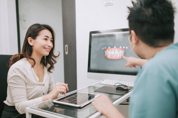 istock asian chinese male dentist explaining Tooth X-Rays To A Patient 1288230131