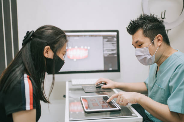 istock asian chinese male dentist explaining Tooth X-Rays To A Patient 1288230167