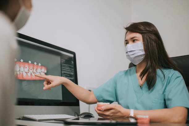 istock asian chinese female dentist explaining Tooth3D To A Patient 1288230192