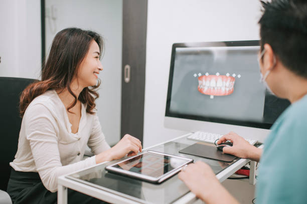 asian chinese male dentist explaining Tooth X-Rays To A Patient asian chinese male dentist explaining Tooth X-Rays To A Patient orthodontist consultation stock pictures, royalty-free photos & images