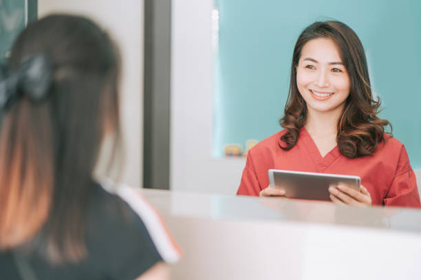 istock asian chinese patient registering at dentist office reception 1288230266