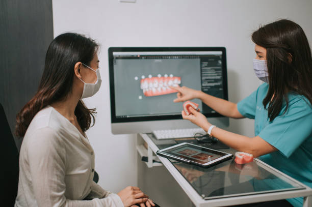 asian chinese female dentist explaining Tooth3D To A Patient asian chinese female dentist explaining Tooth X-Rays To A Patient orthodontist photos stock pictures, royalty-free photos & images