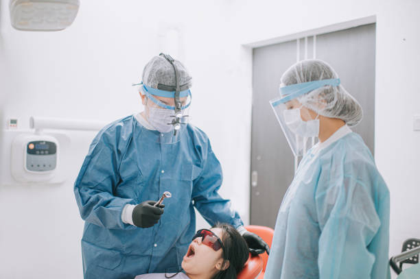 istock asian chinese dentist pulling out bad tooth from patient with pliers 1288230415