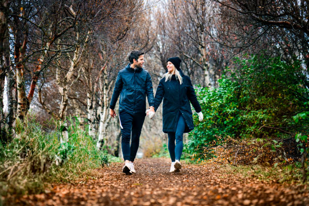 Smiling couple walking at park during autumn
