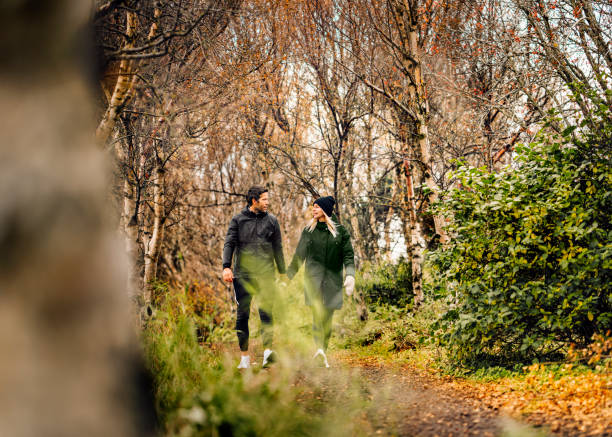 istock Couple holding hands while walking at park 1288233978