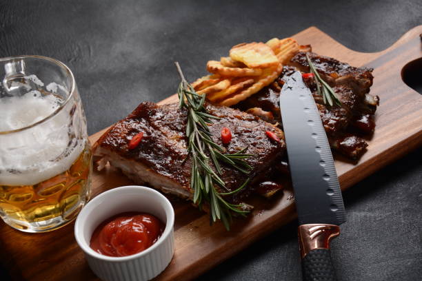 istock Grilled pork ribs with knife, spices on a stone background 1288234392