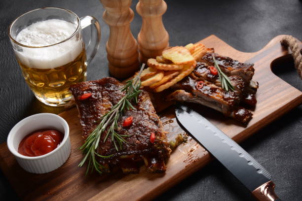 istock Grilled pork ribs with knife, spices on a stone background 1288234402