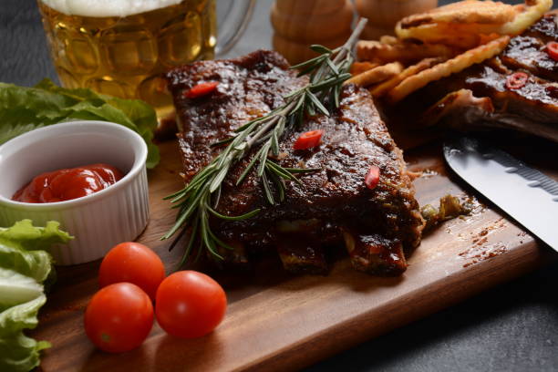 istock Grilled pork ribs with knife, spices on a stone background 1288234423