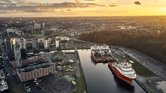 Ships berthed long term. Sunset above  Danish harbor and ships.