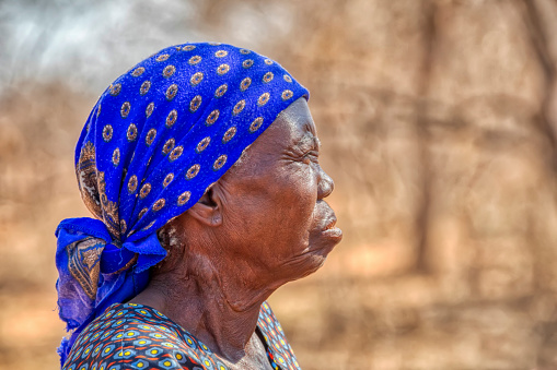 Old African woman sitting down in the yard of her village in Botswana,